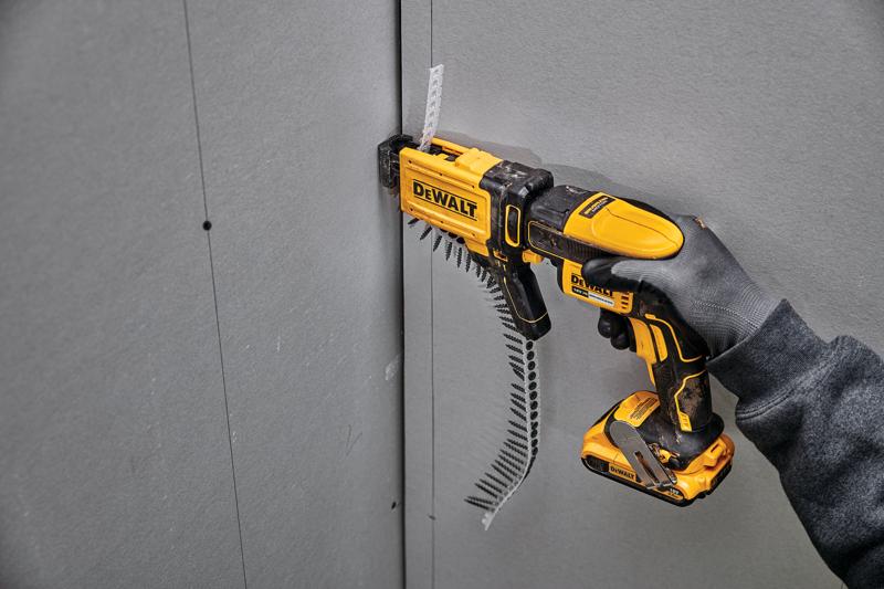 Parafusadeira DEWALT DCF6202 fixando parafusos em drywall, usada por mão com luva.
