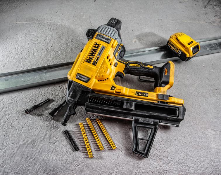 Pistola de pregos DEWALT DCN890P2 com acessórios e fixadores sobre superfície de concreto.